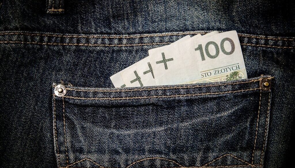 Banknoty 100 zł w kieszeni jeansów