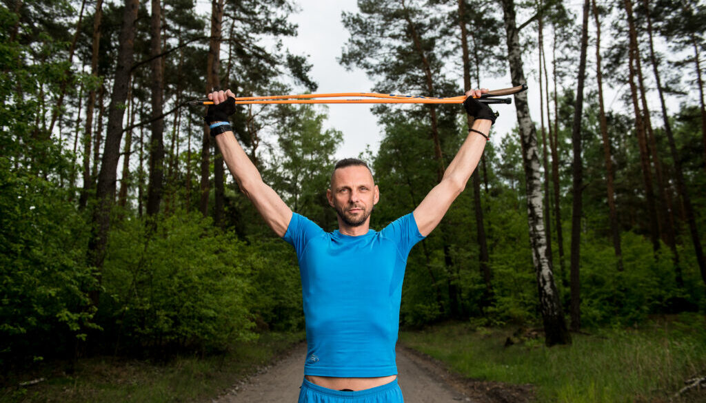 Sławek Bogacki ćwiczy nordic walking na leśnej ścieżce w Brzozówce