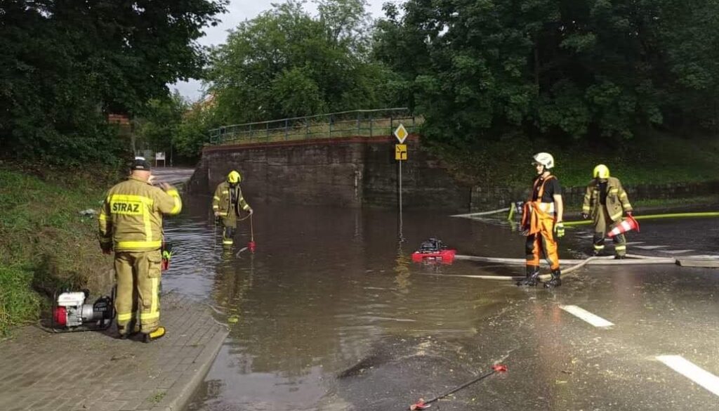 Strażacy na zalanej drodze